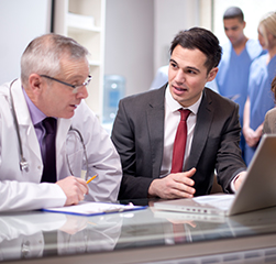 Businessman and doctor in front of laptop